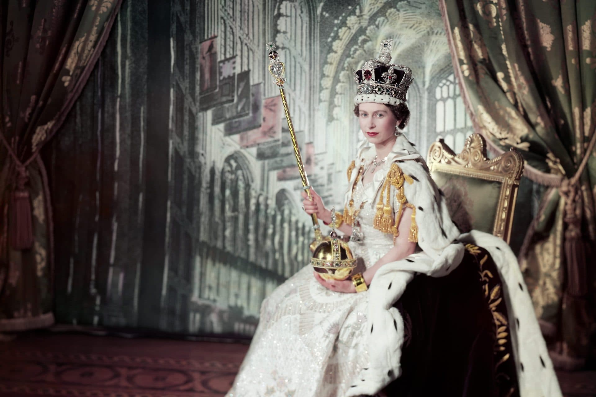 Queen Elizabeth's official coronation portrait, 1953 — seated on a throne in the Imperial State Crown and ermine-trimmed robe, holding the Sovereign's Sceptre and Orb.