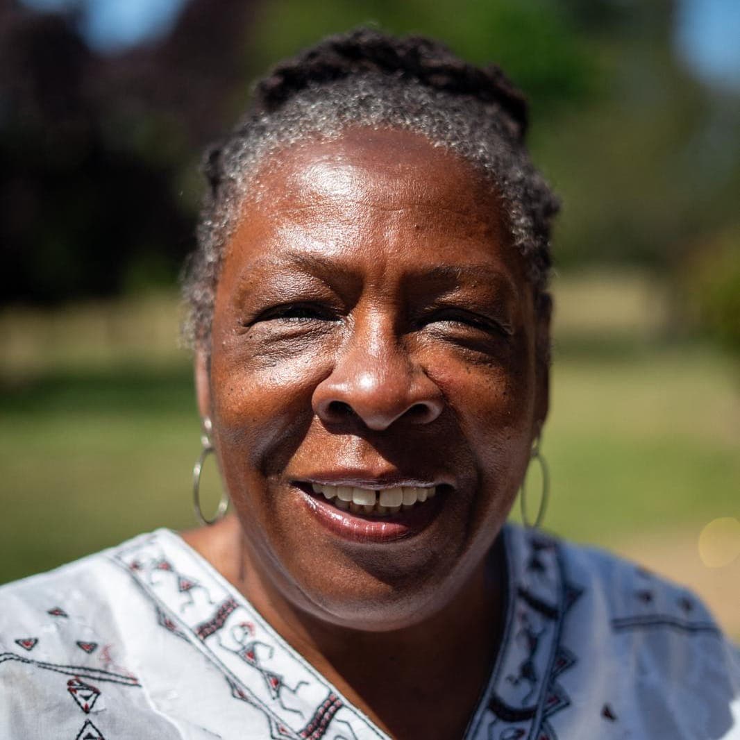 Yvonne Field OBE of The Ubele Initiative, smiling at the camera in a sunlit outdoor portrait.